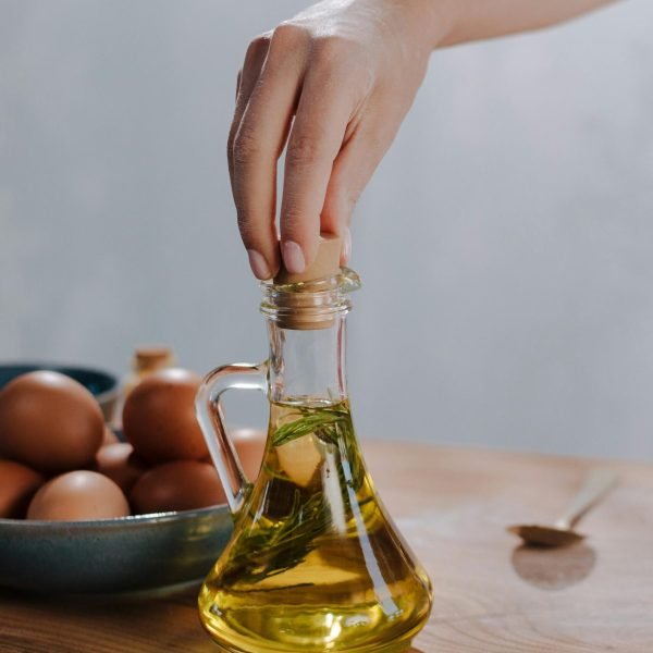 extra virgin olive oil being poured into bowl with olives close up